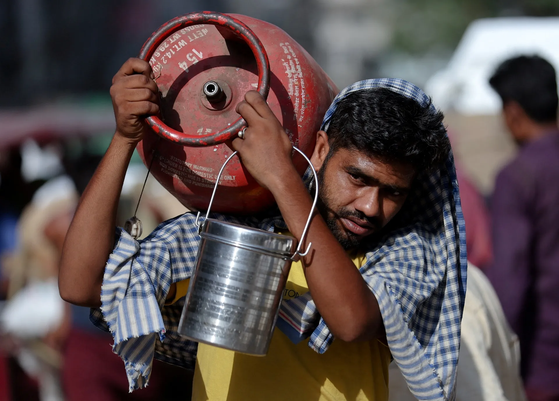A man carries an LPG cylinder on his shoulder at a wholesale market in the old quarters of Delhi, India, June 7, 2023. REUTERS/Anushree Fadnavis