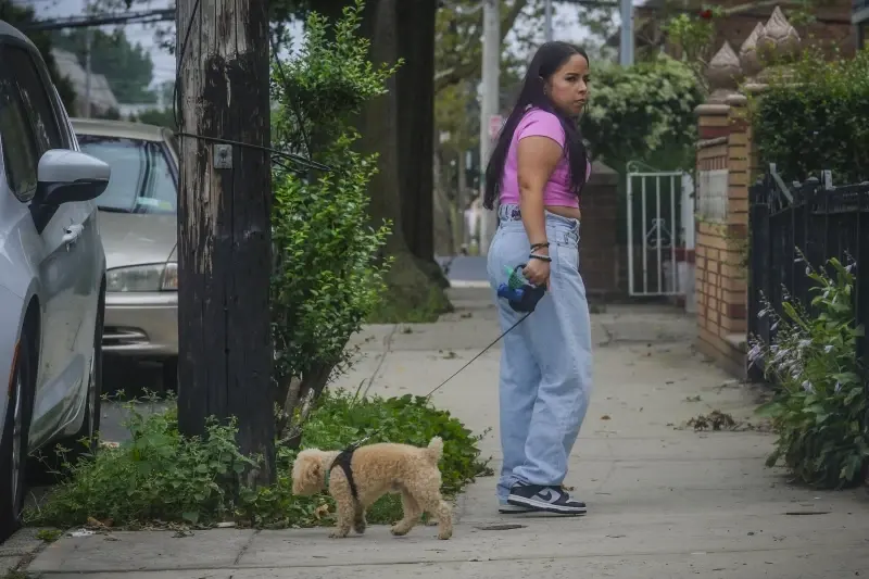 Melissa Chavez walks her toy poodle Milo, Thursday, Aug. 24, 2023, in New York. (AP Photo/Bebeto Matthews)