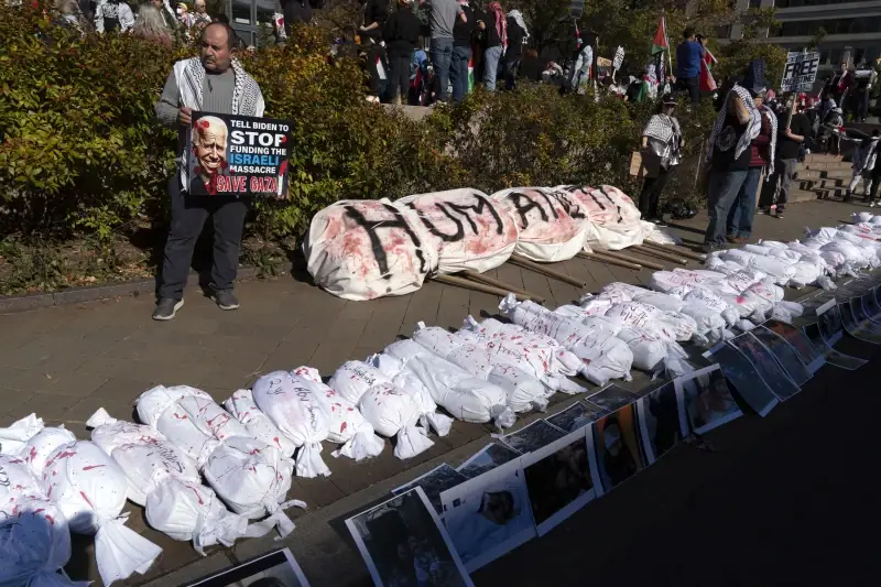 Protesters place white sacks representing the bodies of people killed in Gaza during a pro-Palestinian demonstration at Freedom Plaza in Washington, Saturday, Nov. 4, 2023.