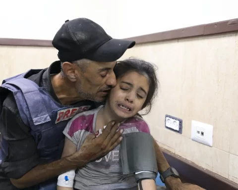 A Palestinian journalist comforts his niece, wounded in an Israeli strike on her family home in a hospital in Deir el-Balah, Gaza Strip, October 22, 2023. Ali Mahmoud/AAP