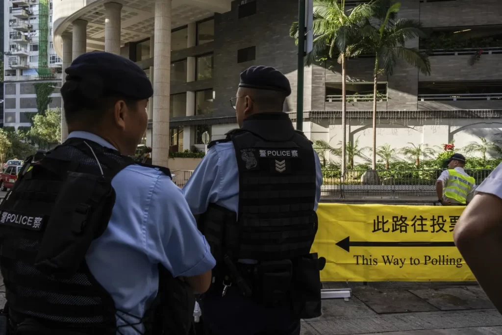 Police officers patrol outside a polling station during the District Council elections in Hong Kong