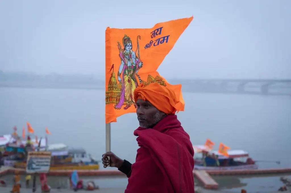 Hindu devotee carries a flag with a picture of Lord Ram on the banks of the Sarayu River