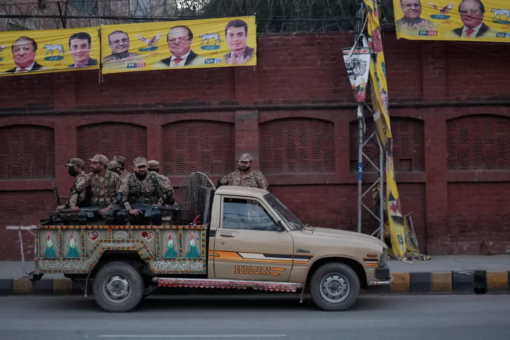 Army personnel sit in a vehicle near a polling station on the day of the general election in Lahore Pakistan