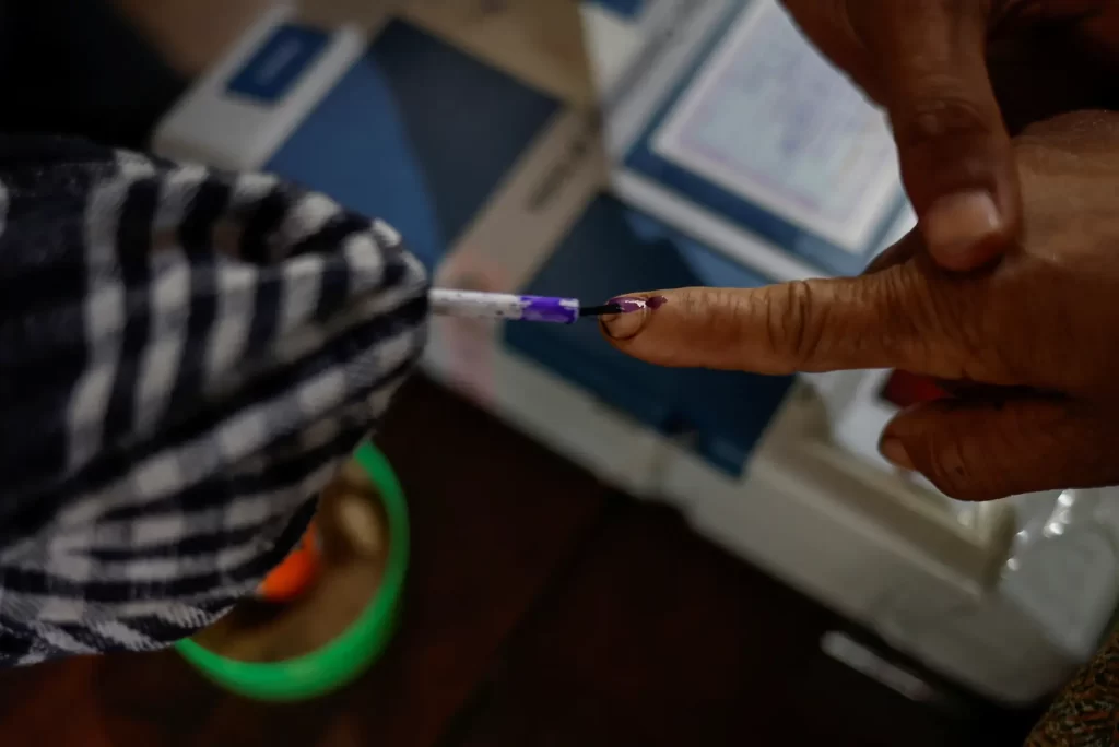 A voter gets his finger inked before casting his vote at a remote polling station in Nongriat village