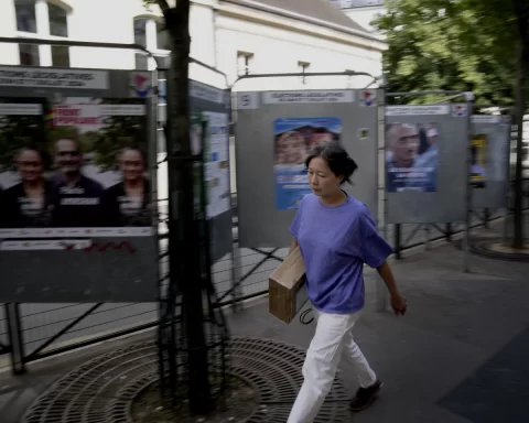 France, A woman walks past campaign boards for the upcoming parliamentary elections in Paris, France