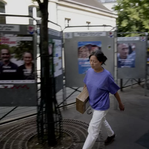 France, A woman walks past campaign boards for the upcoming parliamentary elections in Paris, France