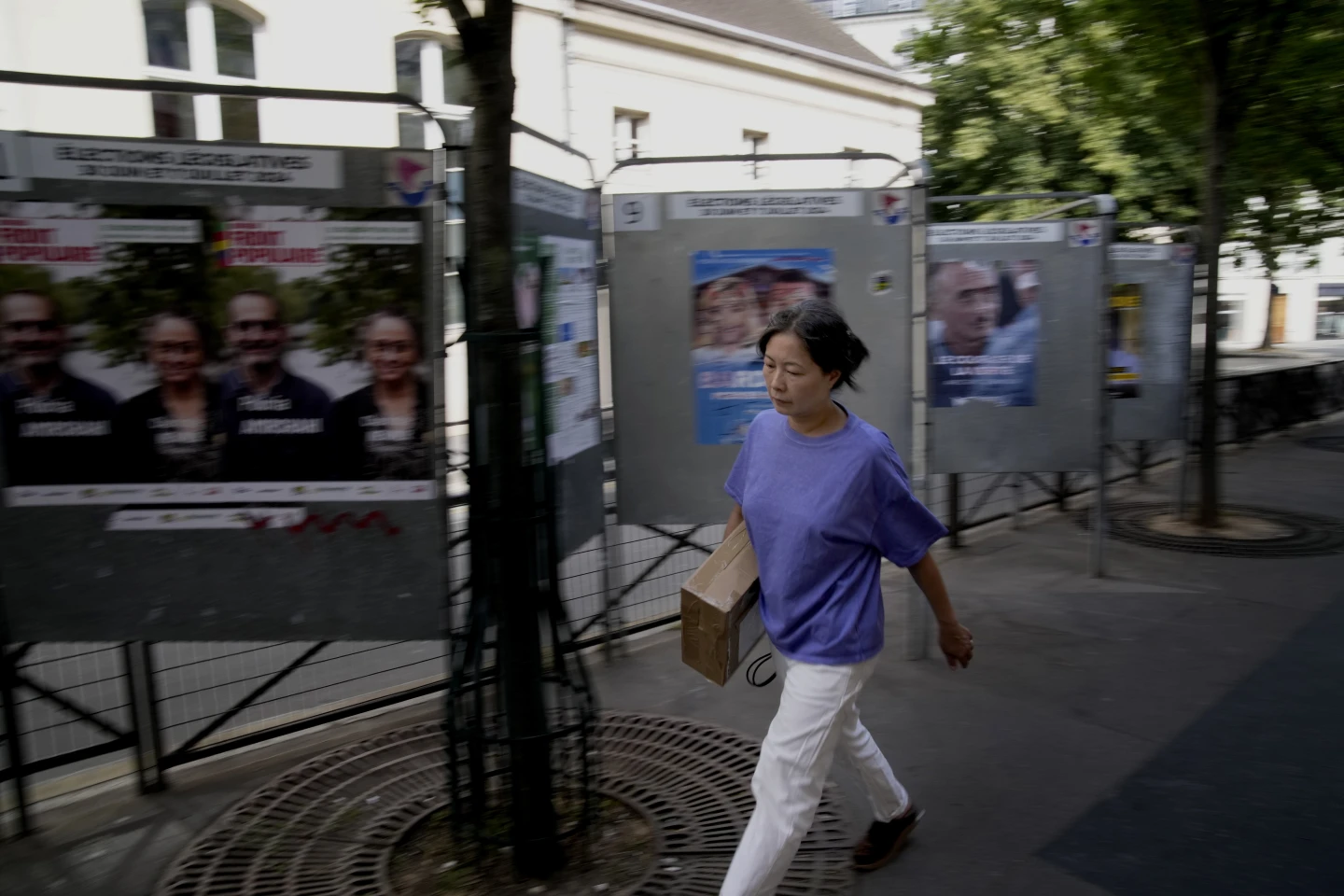 France, A woman walks past campaign boards for the upcoming parliamentary elections in Paris, France