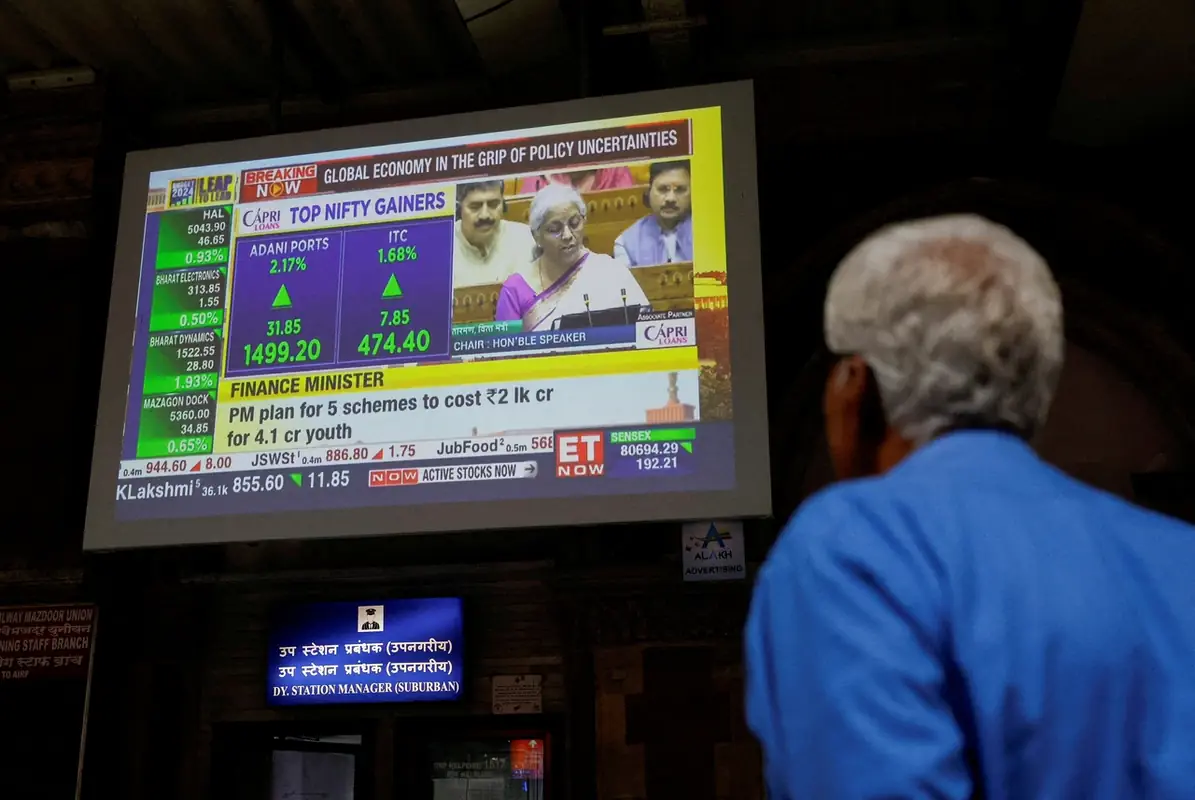 A man watches a screen displaying India's Fin Min. Nirmala Sitharaman's budget speech