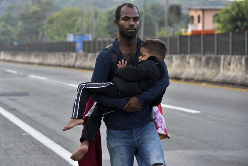 migrant carries a child