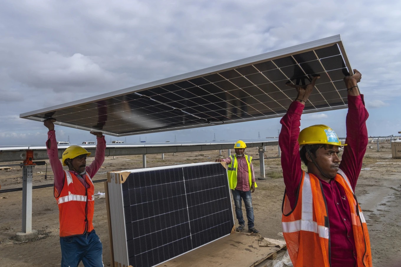 Workers carry solar panel for installation