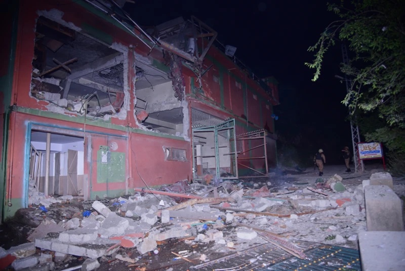 Army soldiers examine a building damaged