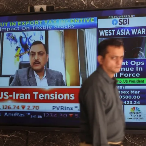 A man walks past a screen displaying the news and stock market updates at the Bombay Stock Exchange (BSE) in Mumbai, India, March 2, 2026. REUTERS/Francis Mascarenha