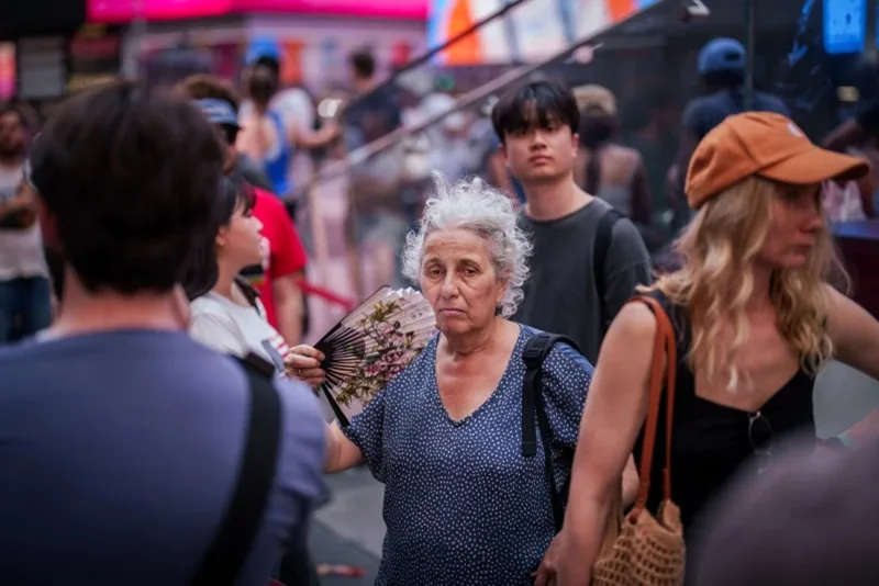 How to stay safe while traveling during extreme heat 3 person uses a fan