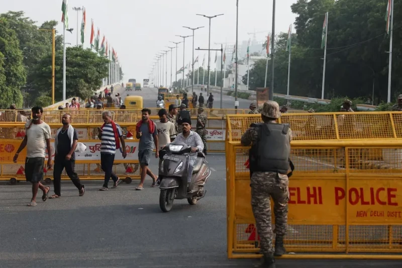 <center><i>Commuters cross a checkpoint as police officers stand guard on the second day of a protest planned by the Cockroach Janta Party (CJP) seeking the resignation of India's Chief Election Commissioner, Gyanesh Kumar, in New Delhi, India, October 11, 2026. (Photo: Reuters) </center></i> 2049098871