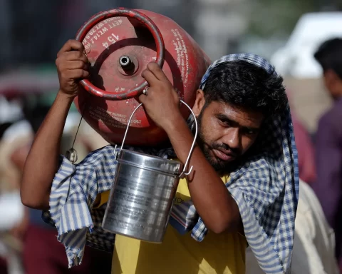 A man carries an LPG cylinder on his shoulder at a wholesale market in the old quarters of Delhi, India, June 7, 2023. REUTERS/Anushree Fadnavis