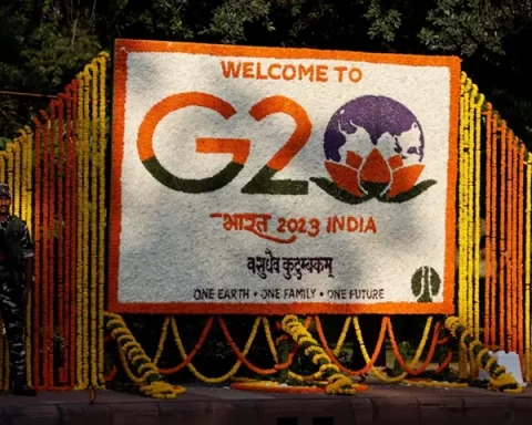 A security force personnel stands guard next to a hoarding decorated with flowers on a pavement ahead of the G20 Summit in New Delhi, India, September 8, 2023