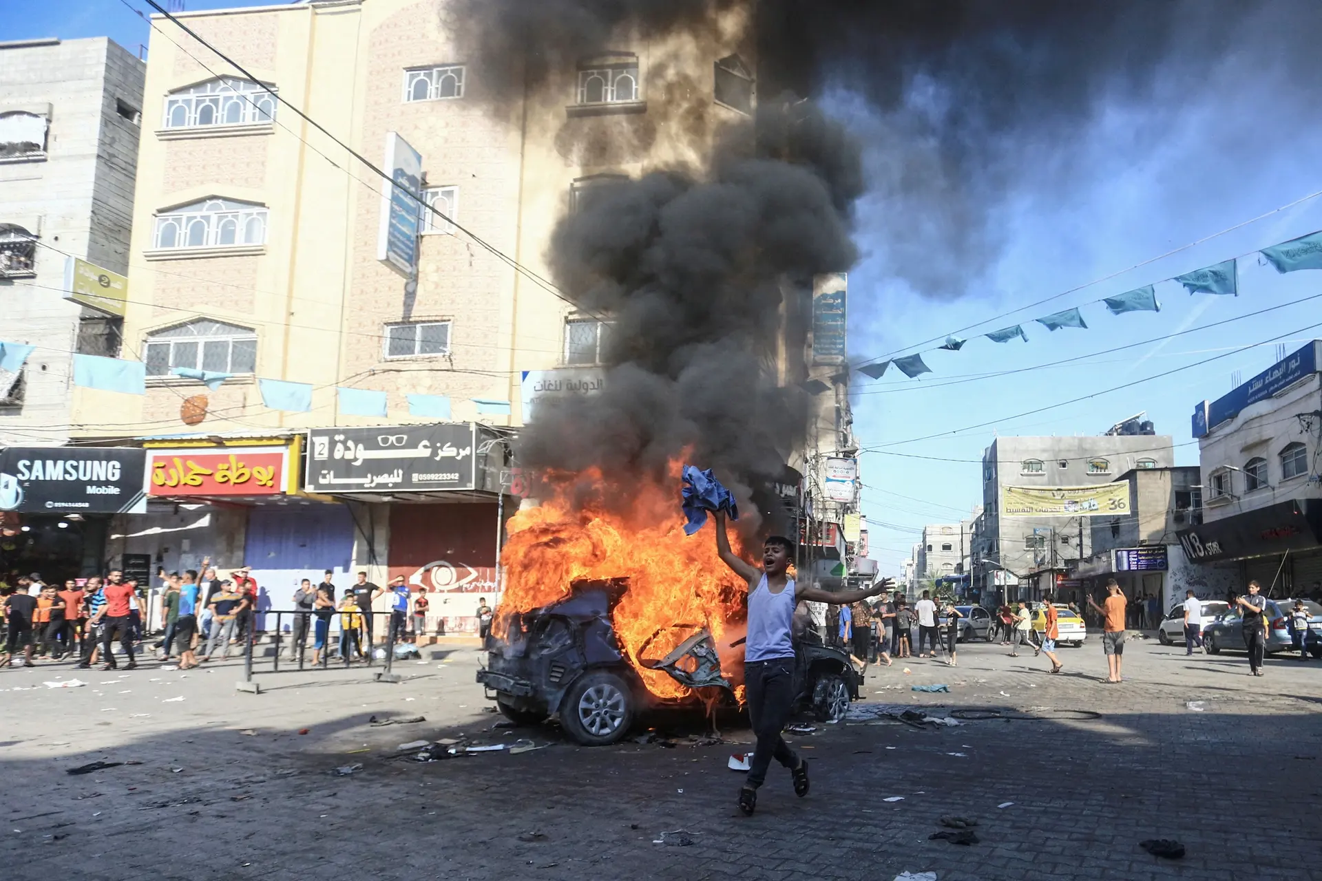 Palestinian boy reacts next to a burning Israeli vehicle - Hamas