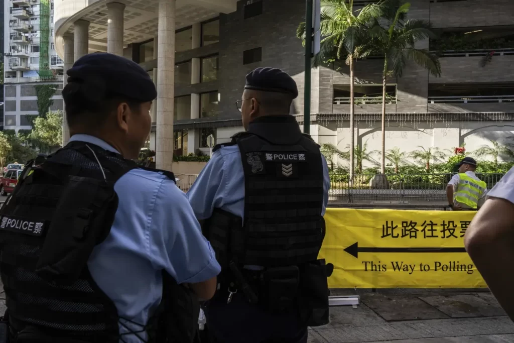 Hong Kong Holds First Council Elеctions: Pro-Dеmocracy Candidatеs Shut Out 2 Police officers patrol outside a polling station during the District Council elections in Hong Kong