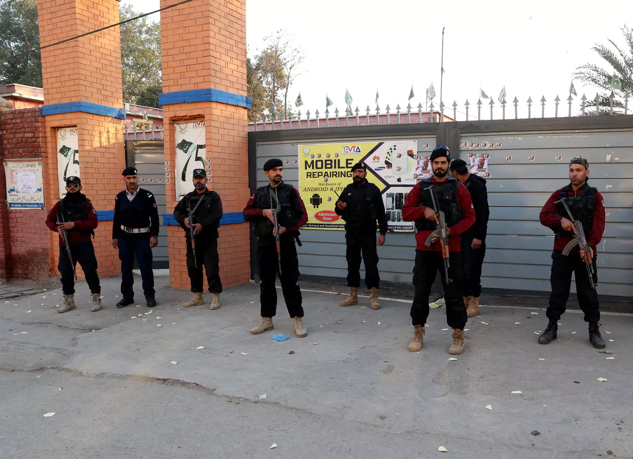 Police officers stand guard outside a polling station in Gulbahar area in Peshawar, Pakistan, February 8, 2024. REUTERS/Fayaz Aziz