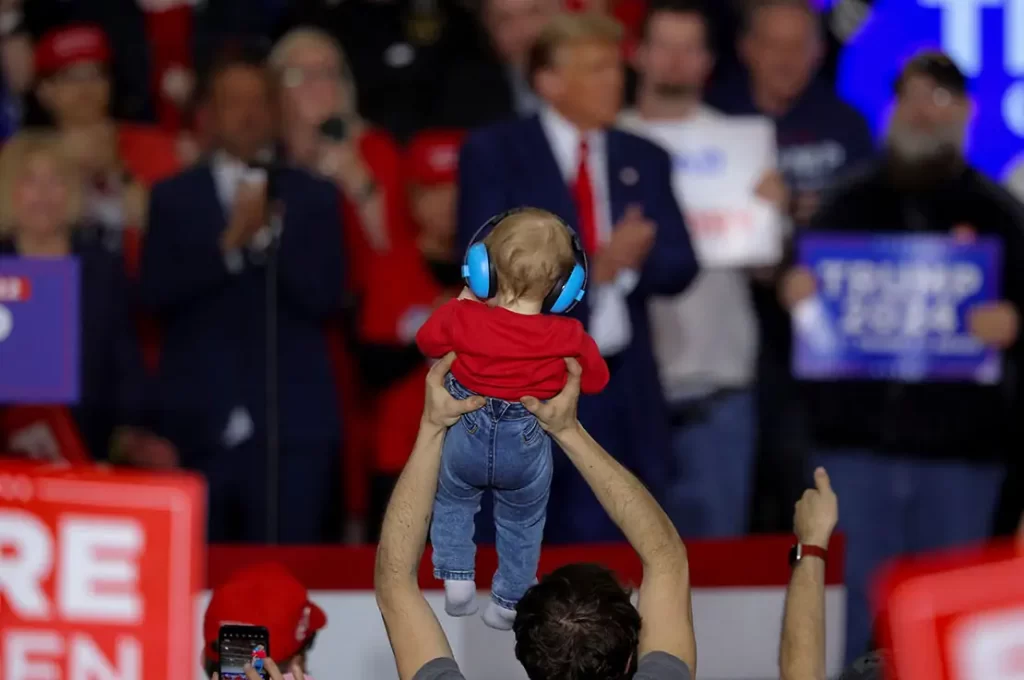 Deconstructing the spectacle and stagecraft of a Donald Trump rally 1 Supporter of Republican Prez candidate Donald Trump holds up a child during the rally in Green Bay