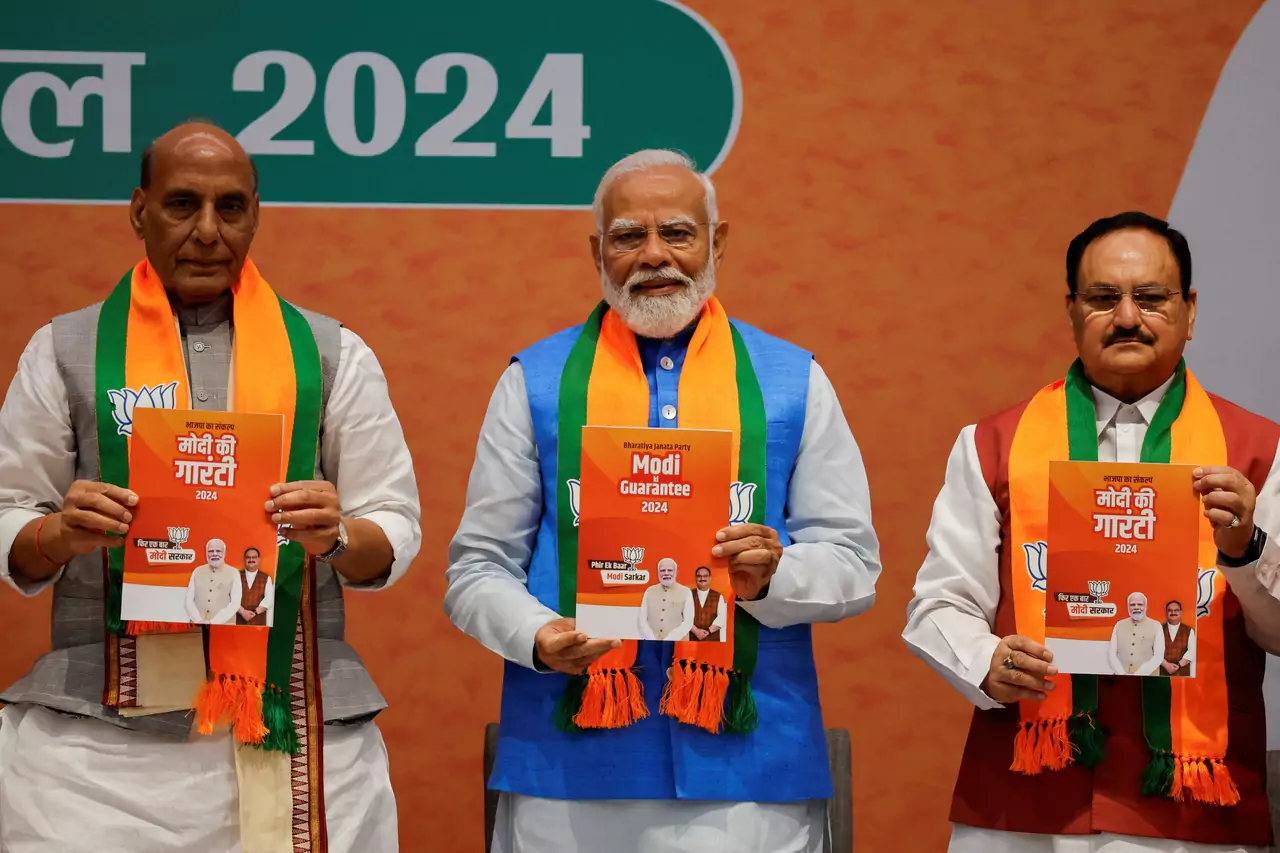 Indian Defence Minister Rajnath Singh, Prime Minister Narendra Modi and President of the Bharatiya Janata Party J. P. Nadda display copies of the ruling Bharatiya Janata Party's (BJP) election manifesto for the general election, in New Delhi, India, April 14, 2024. REUTERS/Adnan Abidi Purchase Licensing Rights
