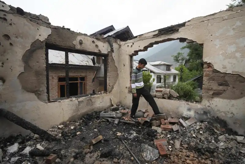 India and Pakistan trade fire and accusations as fears of a wider military confrontation rise 3 village boy walks inside