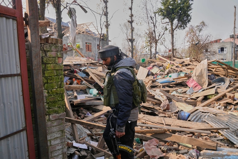 An Army soldier walks past the debris of blown-up home of one of the key suspect behind the Nov. 10 Delhi car blast, in Pulwama, south of Srinagar, Kashmir, on Nov. 14, 2025.