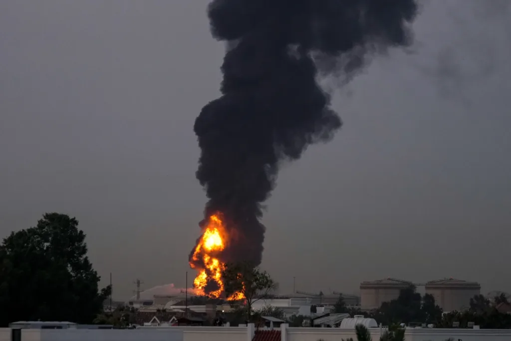 Fire and plumes of smoke rises after s drone struck a fuel tank forcing the temporary suspension of flights. near Dubai International Airport, in United Arab Emirates, early Monday, March 16, 2026. (AP Photo)