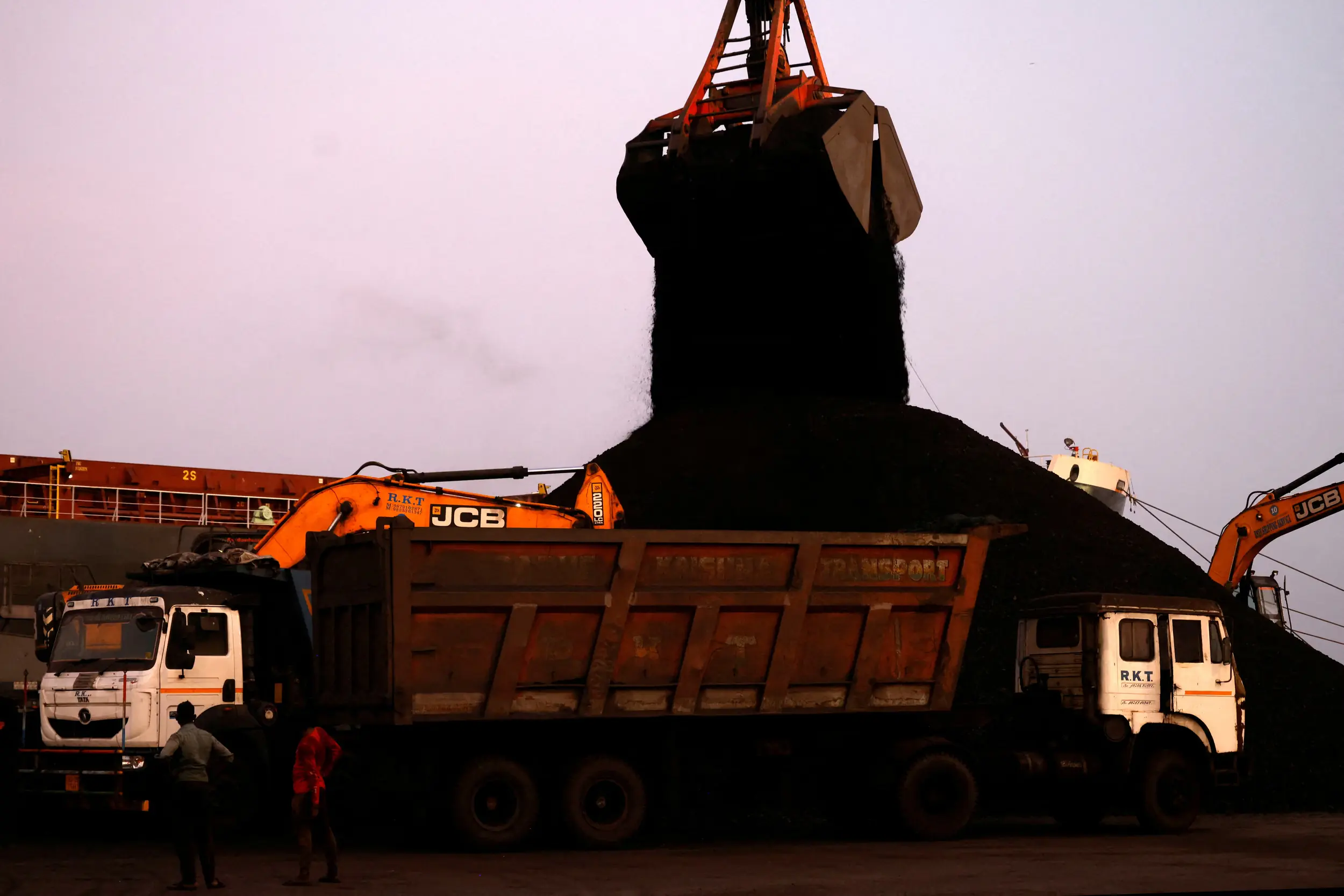 Crane unloads coal from a cargo ship summer