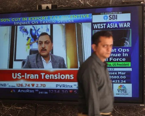 A man walks past a screen displaying the news and stock market updates at the Bombay Stock Exchange (BSE) in Mumbai, India, March 2, 2026. REUTERS/Francis Mascarenha